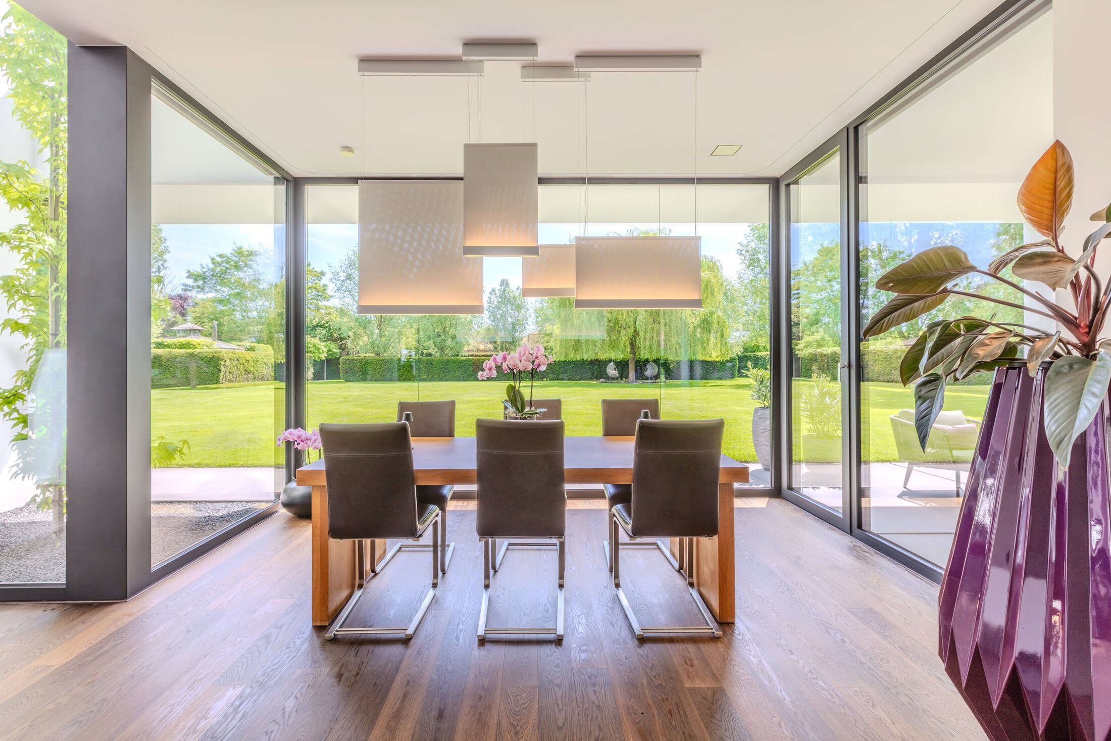Essbereich mit raumhohen Glasfronten und Gartenblick