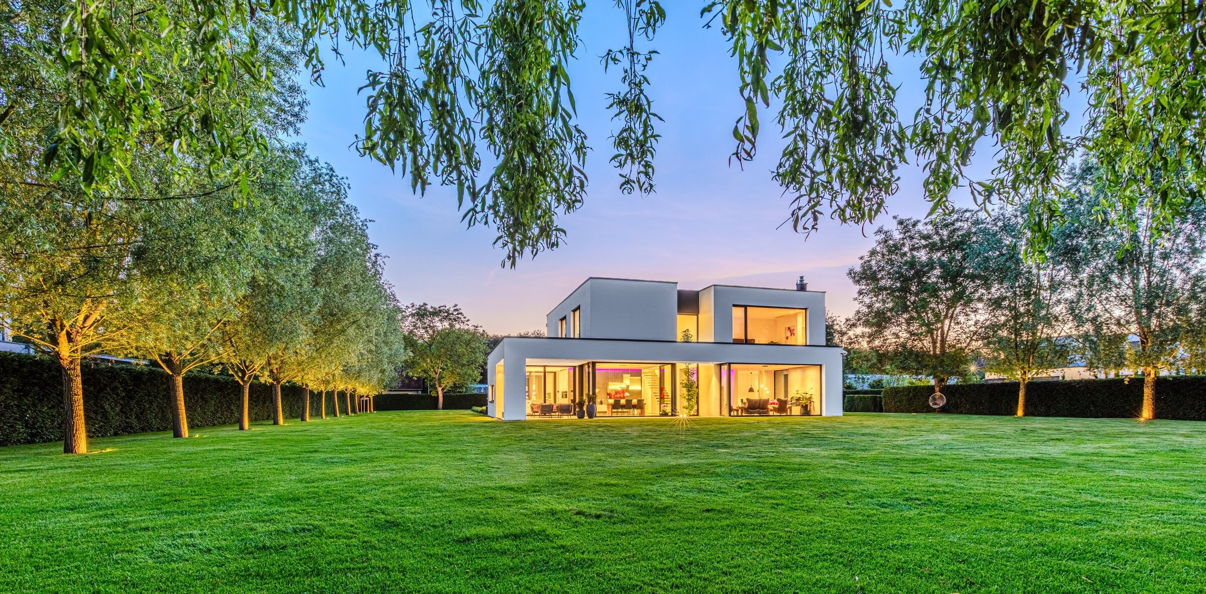 Rückansicht der Villa bei Nacht mit Gartenblick