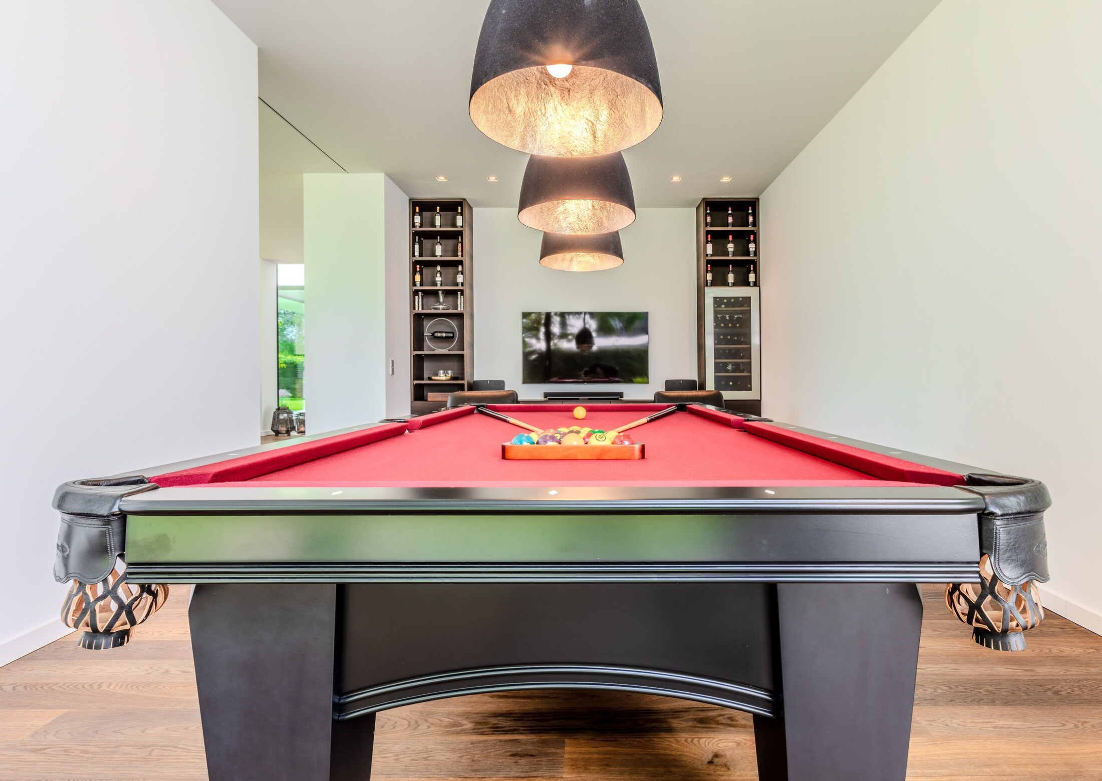 Herrenzimmer mit Billardtisch, Weinregal und Designer-Leuchten