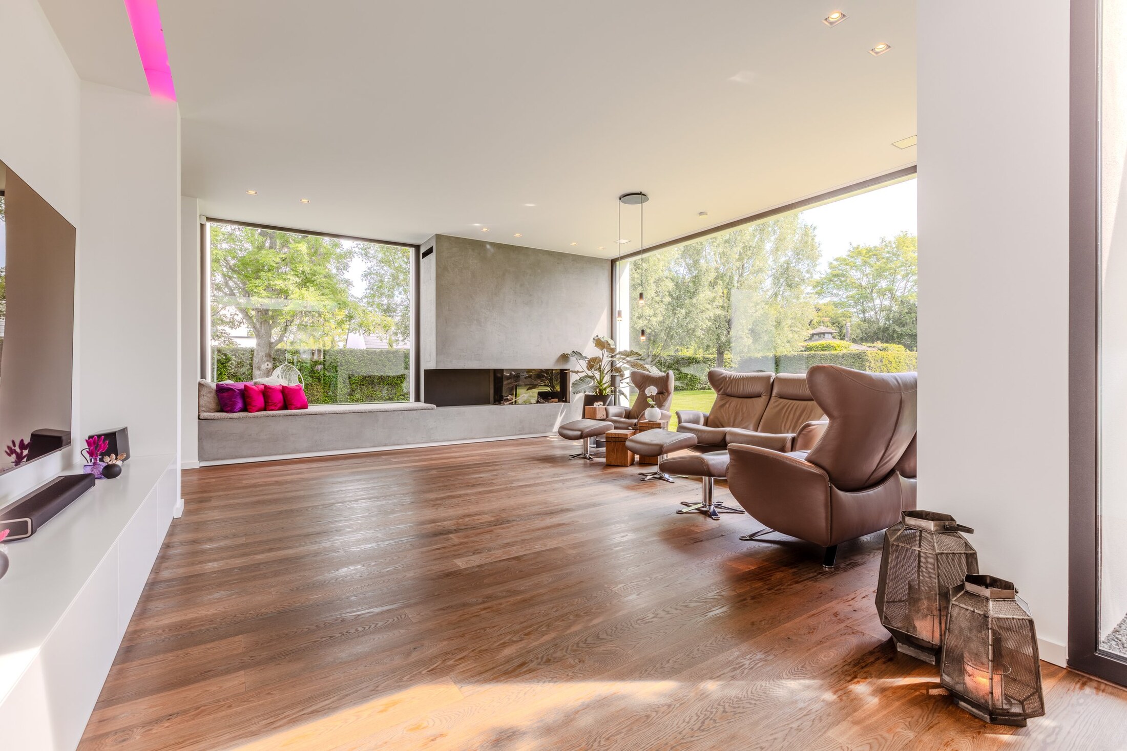 Lounge mit Gaskamin, Eichenparkett und Panorama-Glasfront zum Garten