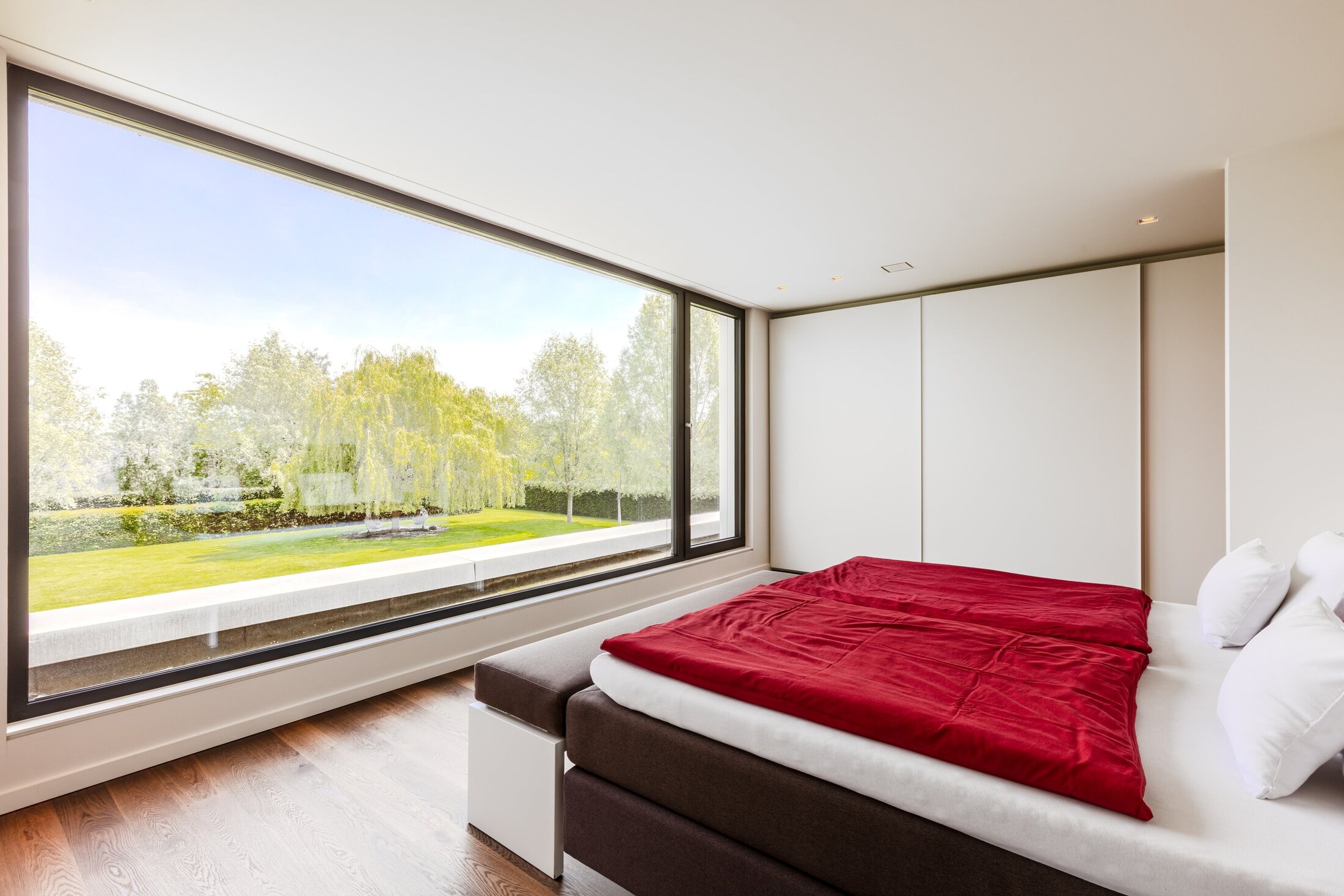 Master Suite mit Panoramafenster und Gartenblick