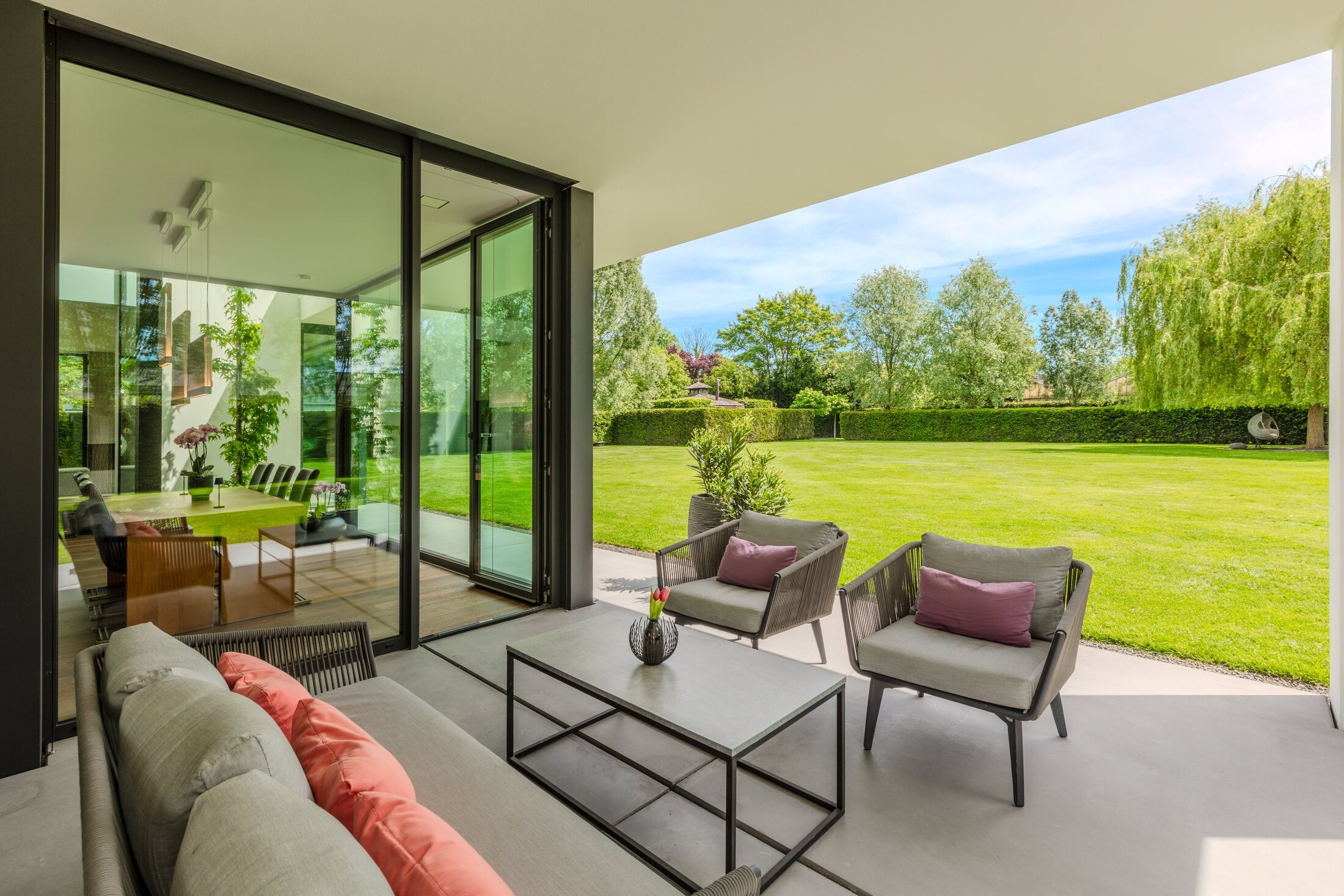 Überdachte Terrasse mit Designer-Lounge bei Abendlicht