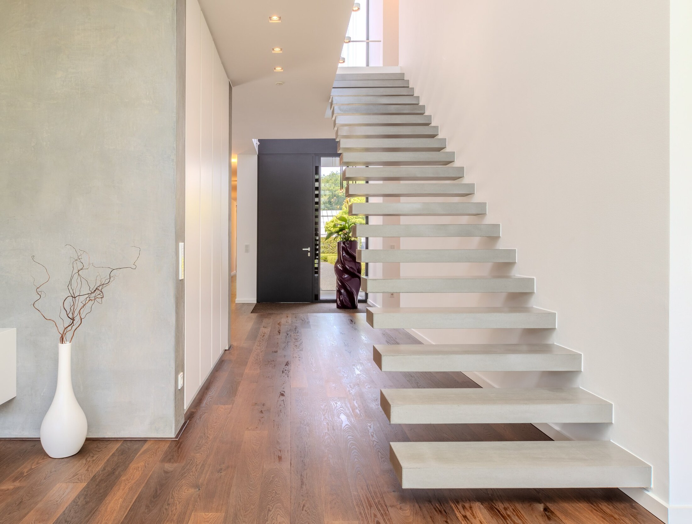 Freitragende Betontreppe mit Sichtbeton und Eichenparkett