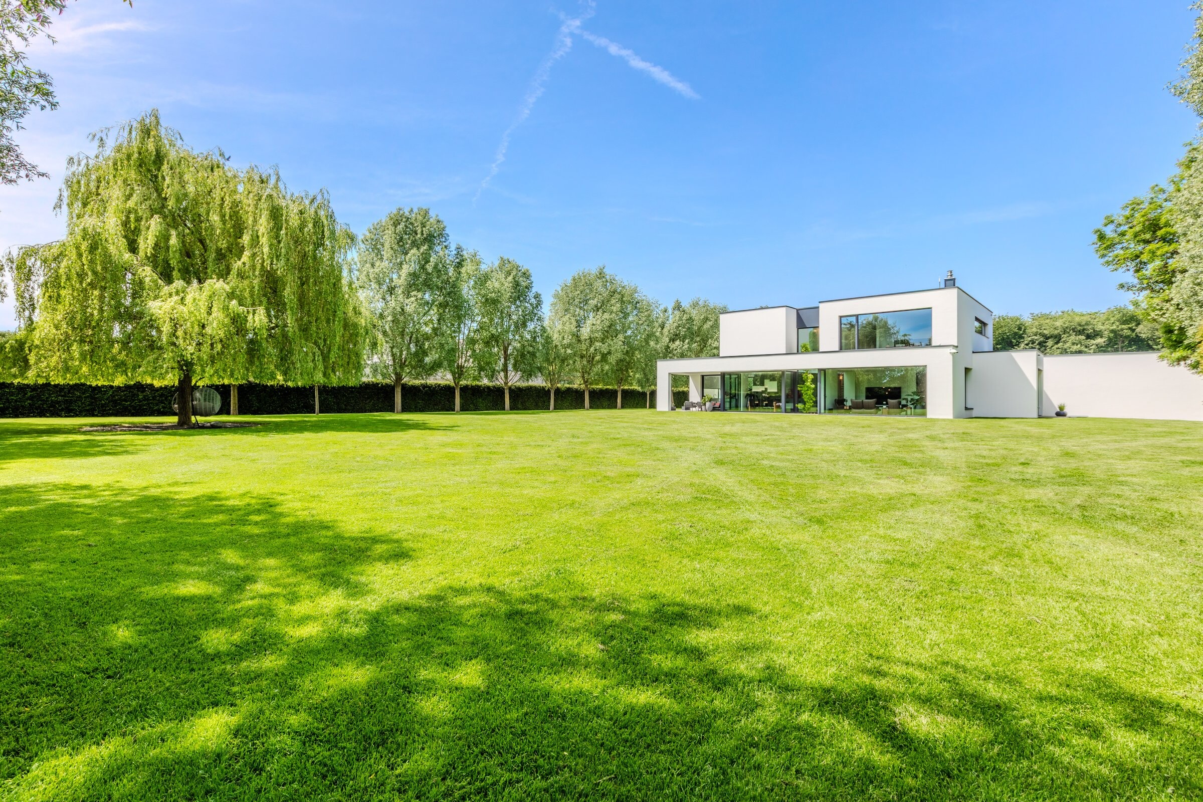 Panorama der Bauhausvilla bei Tageslicht — kubische Klarheit auf parkähnlichem Grundstück