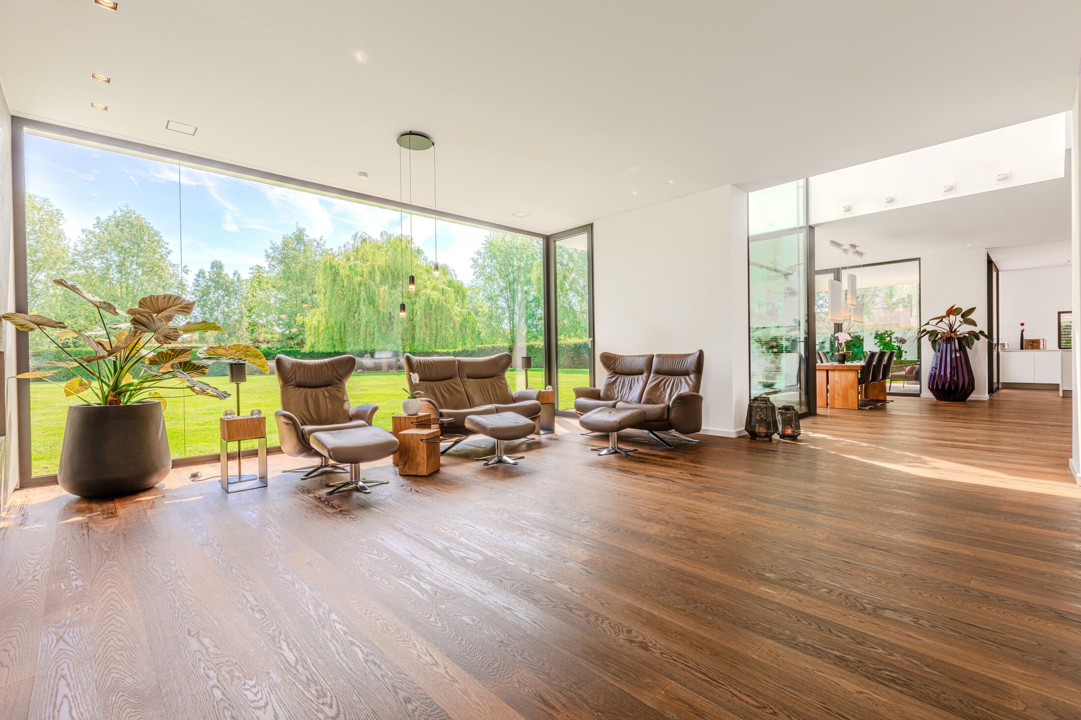 Lounge mit raumhoher Glasfront und Gartenblick